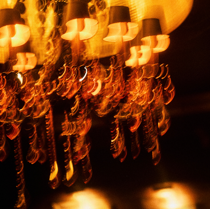 Ornate crystal chandelier with amber lighting creating a warm, elegant ambiance in restaurant interior